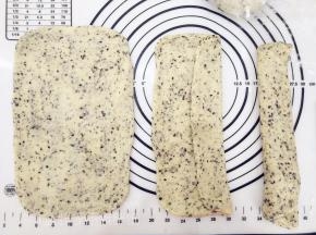 松弛好的面团压扁，用擀面杖擀成长方形面片，折成三折。