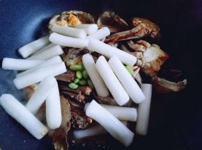 加入年糕，加适量水，烧开，转小火将蟹烧熟。