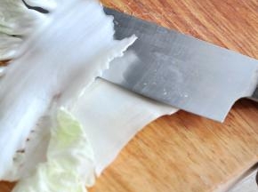 把白菜帮子从中间横切一切，分成两片，再改刀切成片状。