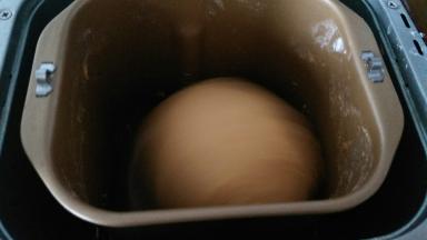 直接开启揉面程序进行排气，然后面团取出，覆盖保鲜膜松弛15分钟