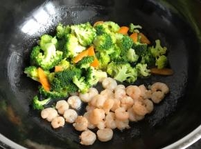 锅中放油烧热，把虾仁放进去煸炒至8成熟；把西兰花和胡萝卜放进去翻炒