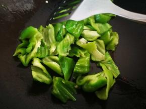 另起一锅，烧热，倒入适量花生油，放下青椒翻炒