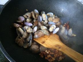 加入花蛤翻炒均匀，加入料酒白糖微炖