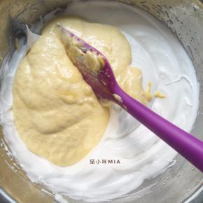 先取三分之一蛋白加入蛋黄糊中，翻拌均匀后再倒回剩余的蛋白盆中，继续翻拌均匀