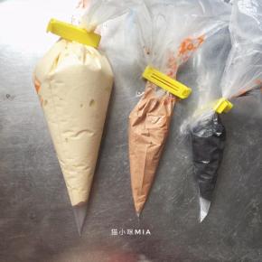 分别取出少许面糊到两个盆中，一份加入可可粉，一份加入黑炭粉，翻拌均匀，装入裱花袋中