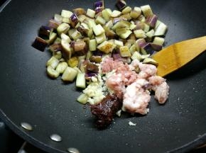 然后加入一小勺的油，加入肉末蒜蓉和郫县豆瓣酱