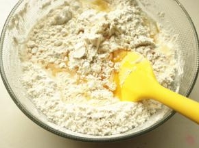 玉米油和牛奶混合均匀，加入进去，混合成团。