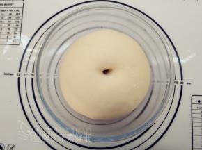 面团团圆之后放入大碗中，盖上保鲜膜，放到温暖的地方，室温发酵。大概50分钟后，面团发酵到两倍大，手指沾面粉戳一个洞，不回缩、不塌陷即表示发酵完成。