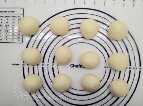 发酵好的面团按压排气，平均分成12个面团，将它们都滚圆之后盖上保鲜膜松弛15分钟。