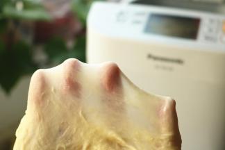 再次开启面包机，分次放入室温软化的黄油，再揉一个15分钟的面团程序，可以轻松拉出手套膜来。