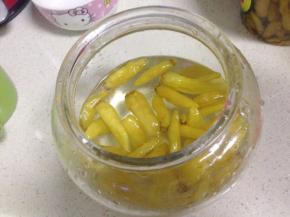 把融化的水、泡椒、泡椒水倒入玻璃罐里，尝下咸淡，不够再加点盐，再加入米醋拌匀