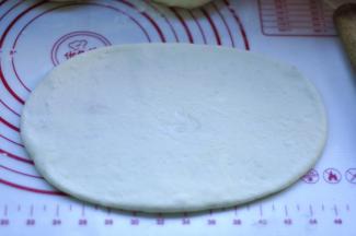 6、将松弛好的面团收口朝下，擀成长方形的薄片