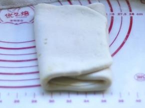 9、将折好的面皮再次擀成长方形，再进行一次三折