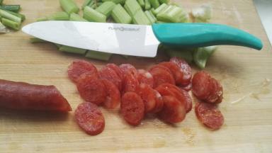 芹菜切段，腊肠斜切薄片，用奈瓷刀切的腊肠无连刀，不掉肉屑，切面光滑、干净利落。