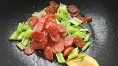 放入腊肠片翻炒。