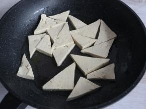 平底锅倒入适量食用油，比平时炒菜多一倍就可以，放入豆腐块，中火煎制。