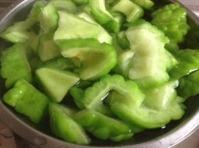 在焖煮的时候，另一边将苦瓜焯水3分钟后捞起，再放进清水中，拧干水份备用