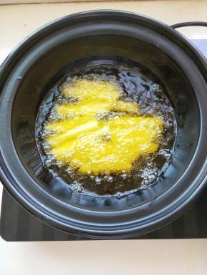 电陶炉开启煎炒健放入砂锅加热放入植物油，油温升起放入土豆条炸至微黄