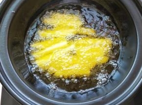 电陶炉开启煎炒健放入砂锅加热放入植物油，油温升起放入土豆条炸至微黄