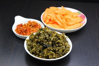 酸菜洗净切好，胡萝卜去皮洗净切片，干辣椒一半剁碎，一半留个；