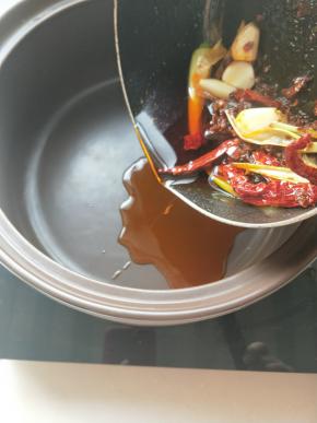 电陶炉启动放上砂锅，将炒好的酱料倒入砂锅