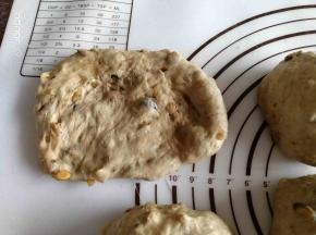 用手按扁排气，提起四个角，揉圆。