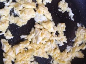 锅内倒入适量食用油，将鸡蛋煸炒边划散成小块，盛出备用。
