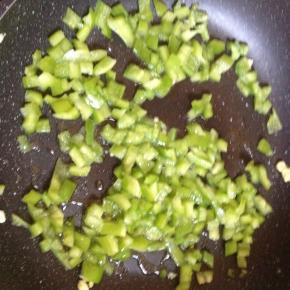 锅内留底油，倒入青椒粒翻炒。