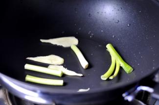 4、另起一锅，锅里放入葱和姜铺在底部，加少许底油。