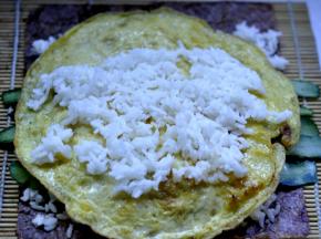 6、在鸡蛋饼上面再放少许米饭