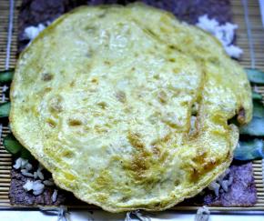 5、再放入黄瓜，上面再铺一层米饭，盖上鸡蛋饼。