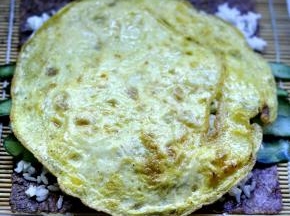 5、再放入黄瓜，上面再铺一层米饭，盖上鸡蛋饼。