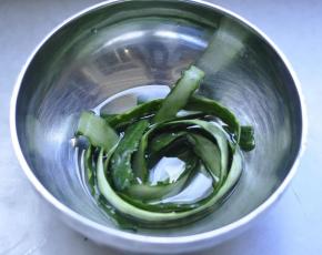 1、黄瓜洗净，用刮皮刀把黄瓜皮顺长条刮下来，放入热盐水中浸泡备用。。