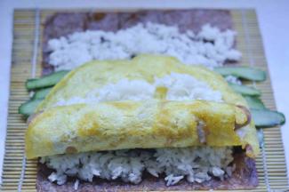 7、放入香肠，先用鸡蛋饼把香肠卷起来 