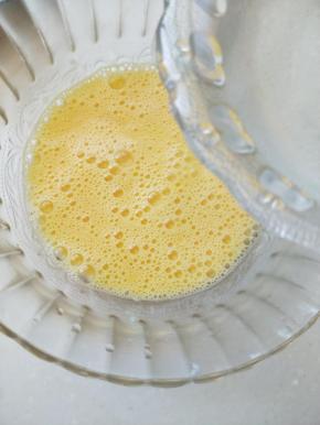 ②用筷子划散成细滑的蛋液。（一定要把鸡蛋打散，不然蒸出来会不均匀，还可能会掺杂蛋白）水烧开后放凉，倒入蛋液中，边倒边搅拌，水与蛋液的比例为2:1。