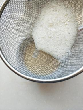 ④蛋液过筛倒入蒸碗中。（盘比碗浅，蒸鸡蛋的时候，蛋液中部和底部更容易蒸熟，不会不均匀）用勺子将过筛后蛋液表面的浮沫刮掉。（一定要保持蛋液无气泡的状态，蒸出来才会细腻）