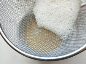 ④蛋液过筛倒入蒸碗中。（盘比碗浅，蒸鸡蛋的时候，蛋液中部和底部更容易蒸熟，不会不均匀）用勺子将过筛后蛋液表面的浮沫刮掉。（一定要保持蛋液无气泡的状态，蒸出来才会细腻）