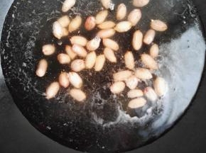 3  花生倒入开水中煮熟，捞出备用。