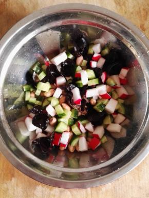 5  花生、黑木耳、黄瓜和水萝卜倒入盆中，混合。