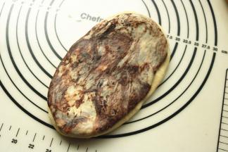 取一份可可面团和白面团，按压成片，摞在一起，再擀的略大一些。