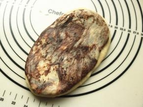 取一份可可面团和白面团，按压成片，摞在一起，再擀的略大一些。