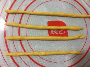 将十份面团中的每一份再次分成两份。一小份搓成长条，一共搓四个长条备用。
