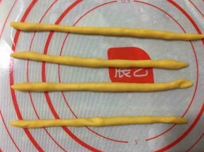 将十份面团中的每一份再次分成两份。一小份搓成长条，一共搓四个长条备用。