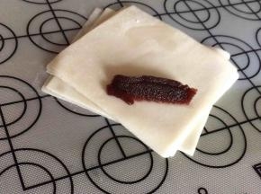 将馄饨角面向自己，靠角挤一段豆沙馅。