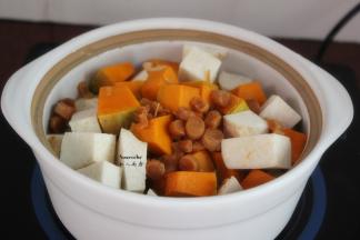 把南瓜块、芋头块，放入瓦煲、再加入浸泡沥干水的干贝、去壳洗净的白果；