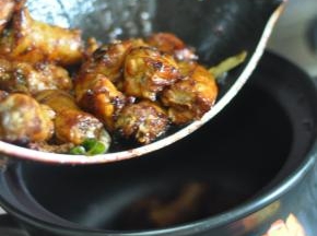 将炒好的鸡脖倒入砂锅中。