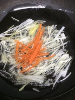 然后下入胡萝卜丝炒几下