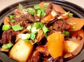 点燃酒精煲，羊排盖上盖子再次烧开，撒上大蒜叶子即可一家人围绕着餐桌慢慢享用这热气腾腾的羊排萝卜小火锅