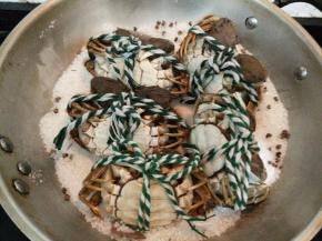 盛起一半的盐，锅里留一半盐铺匀，把大闸蟹背部朝下放在盐上。（如果不想大闸蟹表面沾上盐，可以用锡纸包起来）