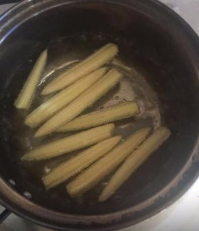 取一锅，放入适量清水煮开，放入清洗好的玉米笋汆烫10秒